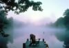 Lake House Rentals: Hidden Gems for a Dreamy Waterfront Getaway Misty dawn dock with Adirondack chair and lanterns.
